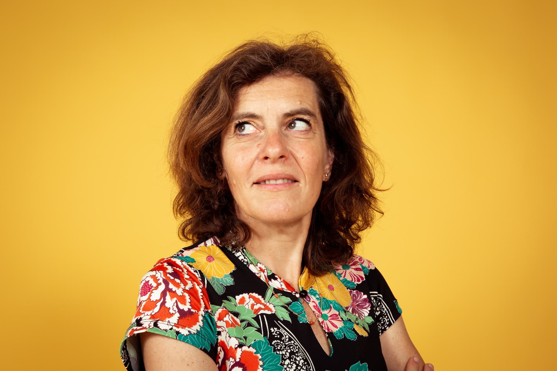 Emily Staphorst kijkt peinzend opzij tegen een gele achtergrond
