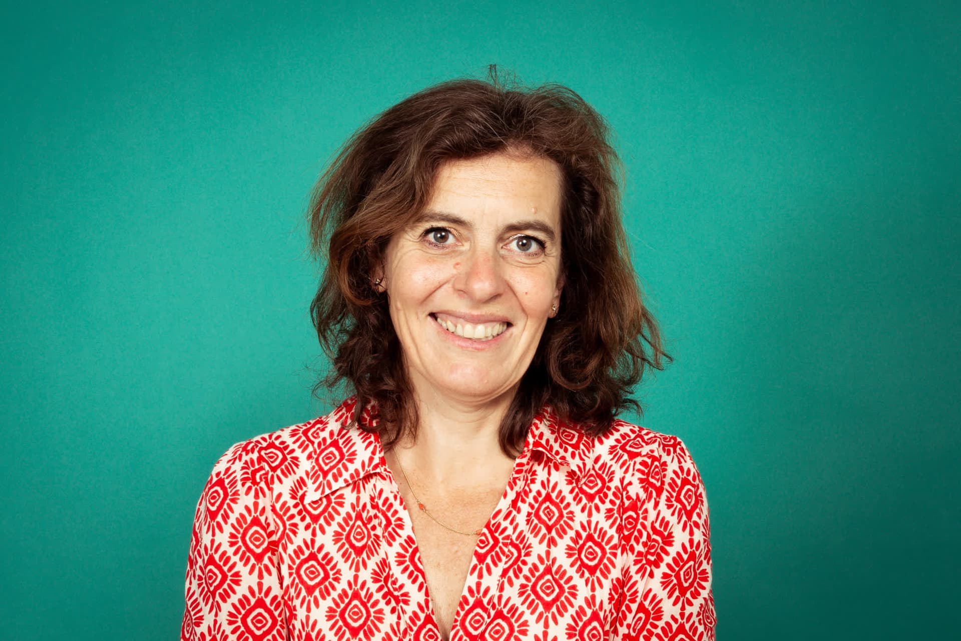 Emily Staphorst lacht breeduit tegen een groene achtergrond